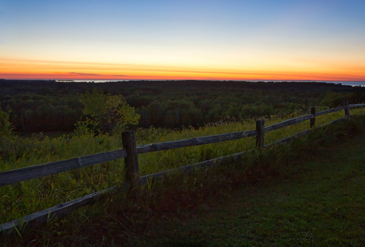 Sunset with a fence in the foreground at Potawatomi State Park.