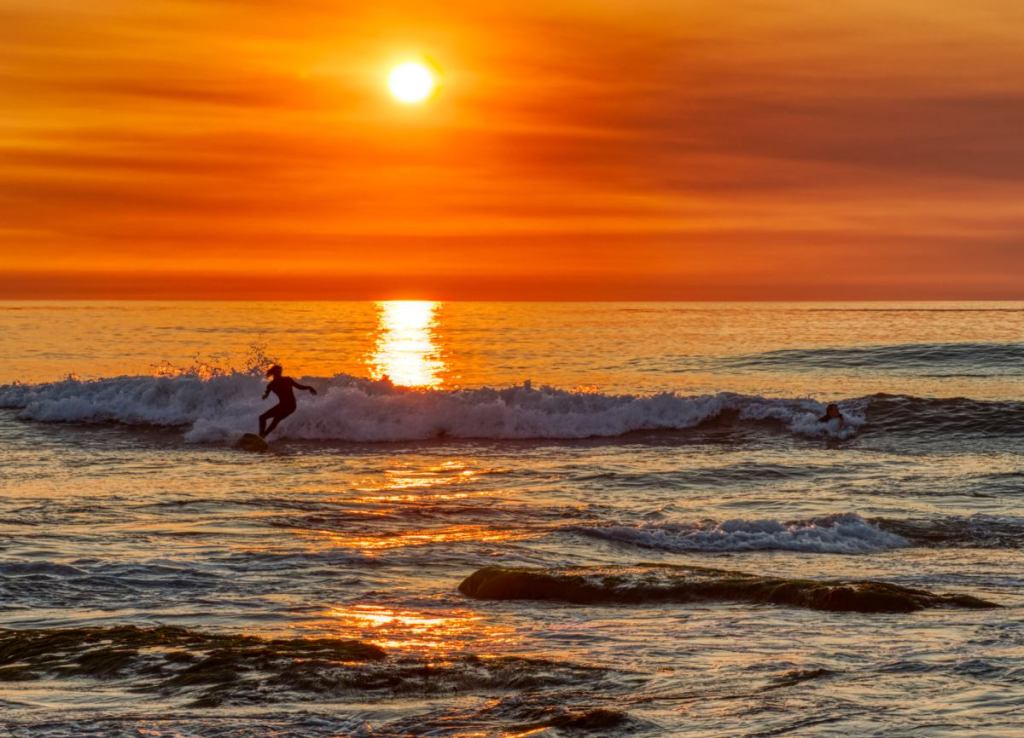 Sunset with a surfer in the foreground