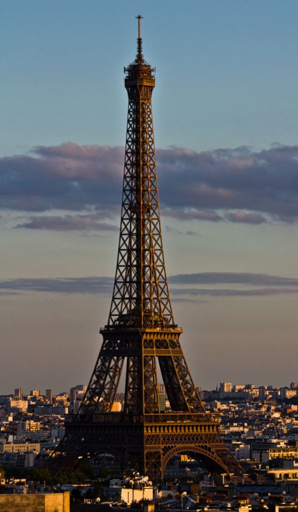 The Eiffel Tower in the warm afternoon sun as seen from the top of the Arc de Triomphe.